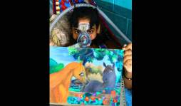 La niña que pinta sueños con su boca, postrada en una hamaca