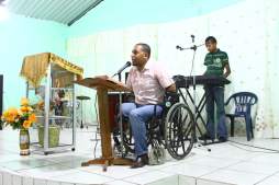 Pastor predica en silla de ruedas tras perder los brazos y una pierna