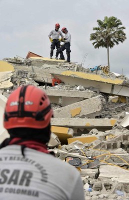 Colombian rescuers search for victims in Pedernales, one of Ecuador's worst-hit towns, on April 18, 2016 two days after a 7.8-magnitude quake hit the country.Rescuers and desperate families clawed through the rubble Monday to pull out survivors of an earthquake that killed 350 people and destroyed towns in a tourist area of Ecuador. / AFP PHOTO / RODRIGO BUENDIA
