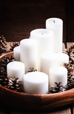 Christmas or New Year's composition with pine cones and white candles, painted snow, vintage wooden background, selective focus