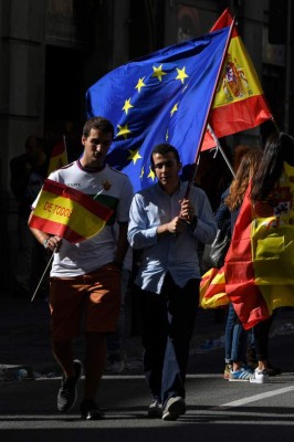 Protesters hold Spanish and European flags after a demonstration called by 'Societat Civil Catalana' (Catalan Civil Society) to support the unity of Spain on October 8, 2017 in Barcelona.The demonstration comes as Catalonia's separatist leaders have vowed to declare independence for the wealthy northeastern region of Spain following a banned secession referendum on October 1. / AFP PHOTO / LLUIS GENE