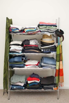 Clothes rack with stacked clothes for male and female, with jeans, tshirts, scarves, hats and more