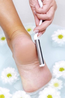 The young woman scrubbing foot in water using clearing brush
