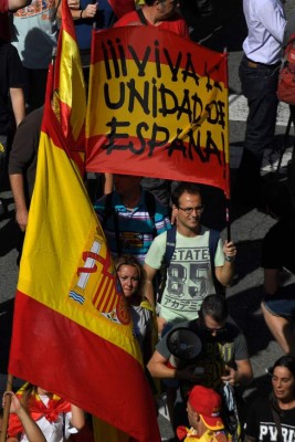 Protesters hols Spanish flags during a demonstration called by 'Societat Civil Catalana' (Catalan Civil Society) to support the unity of Spain on October 8, 2017 in Barcelona.Spain braced for more protests despite tentative signs that the sides may be seeking to defuse the crisis after Madrid offered a first apology to Catalans injured by police during their outlawed independence vote. / AFP PHOTO / LLUIS GENE