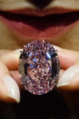 (FILES) This file photo taken on March 29, 2017 shows a model posing with a 59.60-carat oval mixed-cut pink diamond, known as 'The Pink Star', during a Sotheby's media preview in Hong Kong.The pink diamond broke the world record for a gemstone sold at auction, after it fetched 71.2 million USD in Hong Kong on April 4, 2017. / AFP PHOTO / Anthony WALLACE