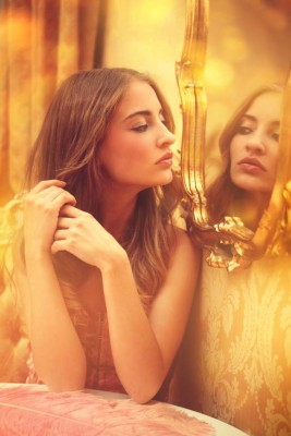 young woman looking at herself in a mirror - venetian bedroom interior