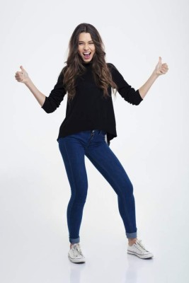 Full length portrait of a cheerful casual woman showing thumbs up isolated on a white background