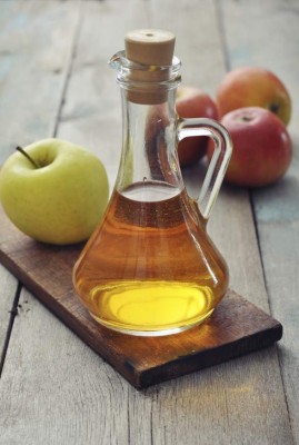 Apple cider vinegar in glass bottle and fresh apples