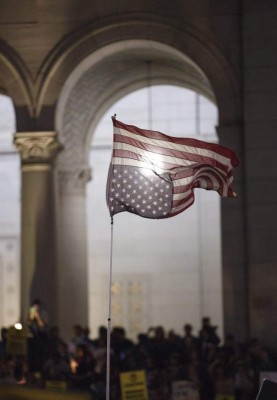 EAG08 LOS ÁNGELES (ESTADOS UNIDOS) 10/11/2016.- Una bandera estadounidense colocada al revés acompaña a un grupo de manifestantes que corea consignas contra la elección de Donald Trump como presidente del país a las puertas del Ayuntamiento de Los Ángeles, California (Estados Unidos) el 9 de noviembre de 2016. Decenas de miles de personas salieron hoy a las calles de las principales ciudades del país para mostrar su rechazo a la decisión salida de las urnas. EFE/Eugene Garcia