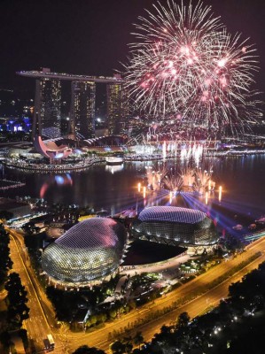 New Year fireworks burst over the Marina Bay skyline in Singapore on January 1, 2017. / AFP PHOTO / ROSLAN RAHMAN