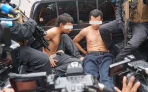 Imagen de archivo muestra a dos presuntos pandilleros capturados durante una redada en San Pedro Sula este año.