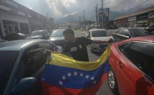 Migrante venezolano recibe dinero de un conductor en la avenida Circunvalación.