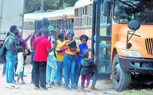 Migrantes de varias nacionalidades abordando buses cerca de la frontera entre Honduras y Nicaragua.