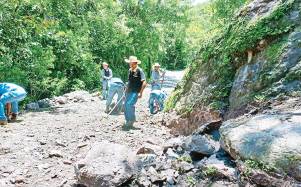 Pobladores que se agencian unos lempiras tapan con tierra los hoyos más peligrosos y dañados del occidente.