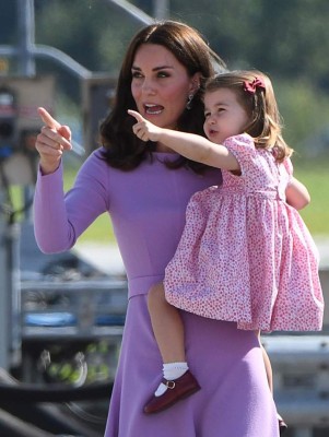 Britain's Princess Kate, the Duchess of Cambridge, attends to her daughter Princess Charlotte as they visit Airbus helicopters on the tarmac of the Airbus compound in Hamburg, northern Germany, on July 21,2017. The British royal couple are on the last stage of their three-day visit to Germany. / AFP PHOTO / Patrik STOLLARZ