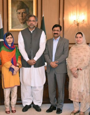 This handout photograph released by the Press Information Department (PID) on March 29, 2018, shows Pakistani Prime Minister Shahid Khaqan Abbasi (2L) posing for a photograph with Pakistani activist and Nobel peace laureate Malala Yousafzai (L) and her parents at the Prime Minister Office during her visit to Islamabad.Nobel peace laureate Malala returned to Pakistan on March 29, saying tearfully that it was 'a dream' to come home for the first time since she was airlifted to Britain after being shot in the head by a Taliban gunman more than five years ago. / AFP PHOTO / PID / HANDOUT