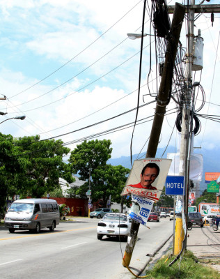 Poste dañado es un peligro en la primera calle