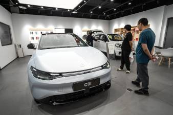 La gente mira vehículos eléctricos dentro de una sala de exposición de Leapmotor en Beijing, China. Imagen de archivo.