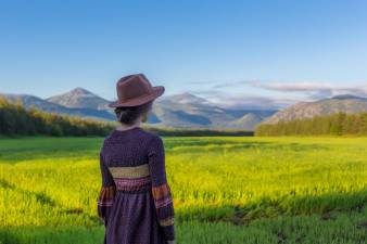 Una mujer mirando el horizonte en un hermoso campo, durante la primavera.