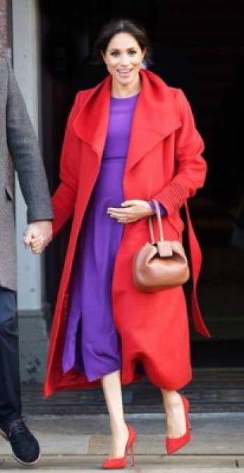 Enero 14 de 2019<br/><br/>Una audaz combinación fue la que lució Meghan con un abrigo largo rojo y un vestido púrpura que resaltaron y lucieron increíbles con su tono de piel. <br/><br/>