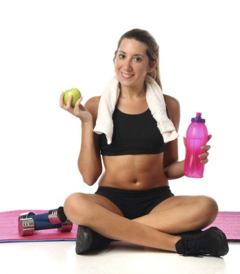 Happy young woman with her fitness equipment over white