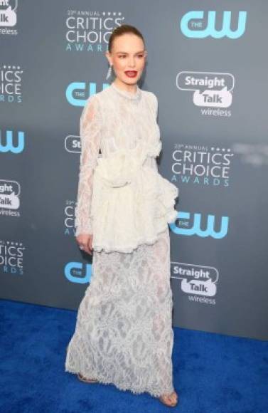 Kate Bosworth usó un vestido largo de de encaje blanco de la Colección Brock, la actriz le dio color a su look con labios en tono rojo.