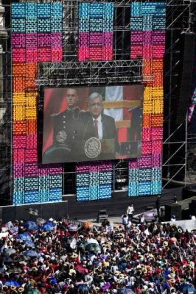 La gente en la plaza del Zócalo, en la Ciudad de México, mirando hoy en pantalla gigante la ceremonia de inauguración del presidente electo de México, Andrés Manuel López Obrador (AMLO).