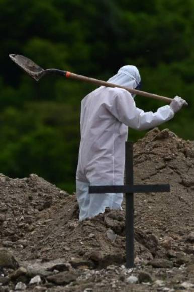 Un sepulturero lleva su pala para cavar una fosa para una víctima de COVID-19 en el cementerio Los Ángeles, a 14 kilómetros al norte de Tegucigalpa.