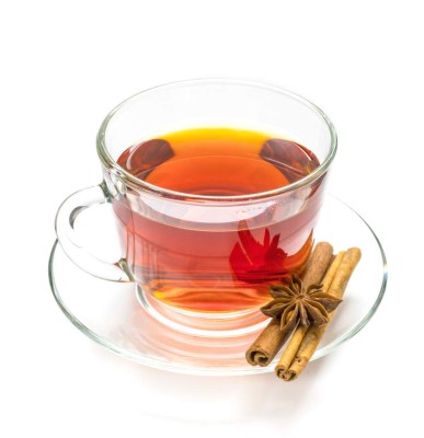 Transparent cup of tea, anise star and cinnamon steaks isolated on white