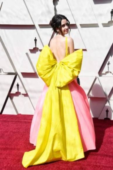 La actriz Laura Marano lució una extravagante corbata en la espalda de su vestido amarillo con rosa.
