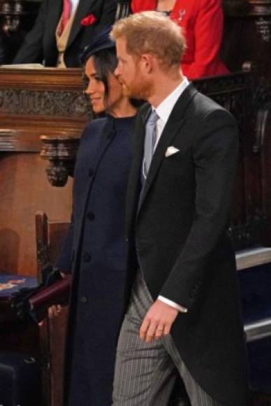 Britain's Meghan, Duchess of Sussex (L) and Britain's Prince Harry, Duke of Sussex, take their seats inside St George's Chapel ahead of the wedding of Britain's Princess Eugenie of York to Jack Brooksbank at Windsor Castle, in Windsor, on October 12, 2018. (Photo by Jonathan Brady / POOL / AFP)