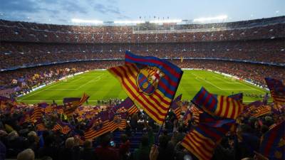 Aficionados del Barcelona ondeando la bandera del club en un partido de Liga.