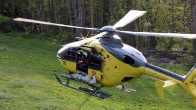 Un helicóptero de rescate de la Generalitat sobrevolando un campo en el Pallars.