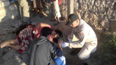 Integrantes del Cuerpo de Bomberos de Honduras brindan asistencia a la mujer que dio a luz en una calle de tierra del occidente de Honduras.