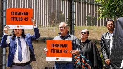 Unas personas sostienen pancartas del Consorcio de Derechos de los Inmigrantes de San Diego (SDIRC) que piden poner fin al Título 42 en San Diego, California.