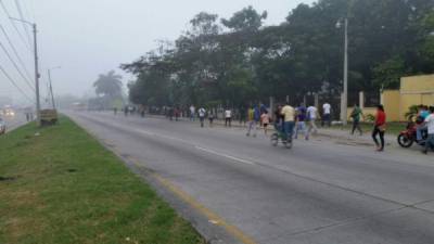 Varios trabajadores se trasladan a pie en Choloma buscando un medio de transporte que los lleve hacia San Pedro Sula.