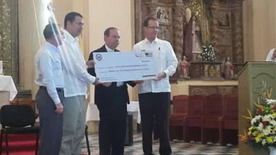 El embajador Nealon entrega el aporte.