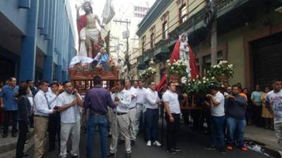 Fieles católicos cargan las figuras de San Juan y San Pedro.