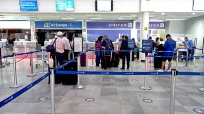 Viajeros hacen fila en las aerolíneas Air Europa y United para hacer sus registros.