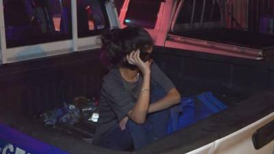 Joven detenida en la paila de una patrulla.