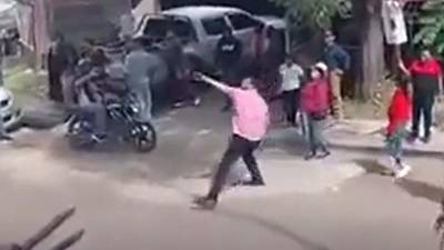 Momento en el que el diputado de Libre, Mauricio Rivera, lanza una piedra al edificio de Ciudad Mujer en Tegucigalpa.