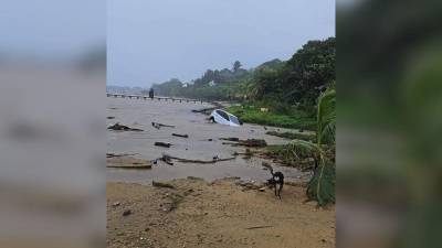 Carro arrastrado por las olas del mar en Roatán.