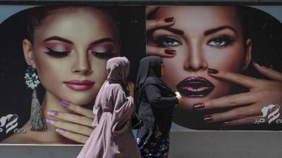 Los anuncios de publicidad de mujeres mostrándose sin el burka poco a poco han sido arrancados o cubiertos con pintura.