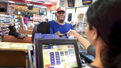 Un hombre compra un boleto de Powerball en una tienda en EUA.