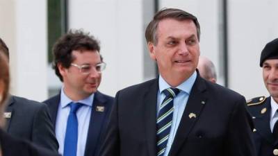 Brazilian President Jair Bolsonaro (L) next to Defense Minister Braga Netto (C) and Army Commander Paulo Sergio Oliveira, attend a military vehicles paradre in front of the Planalto Palace in Brasilia, on August 10, 2021. - Bolsonaro is accused of using the armed forces for a show of force to intimidate National Congress, where a bill is being debated to modify the electronic voting system. (Photo by EVARISTO SA / AFP)