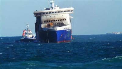 Vista del buque 'Norman Atlantic' (dcha) mientras es remolcado hoy a su llegada al puerto de Brindisi (Italia). EFE