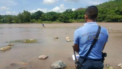 Un elemento de la Policía observa cómo sacan el cadáver de la mujer.
