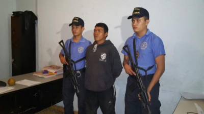 El detenido es custodiado por dos agentes de la Policía Nacional.