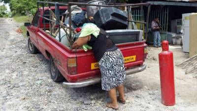 Una mujer carga sus cosas en un vehículo huyendo de los pandilleros en El Salvador. FOTO: tomada del Diario de Hoy.