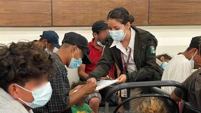 Personal del Instituto Nacional de Migración (INM México) auxiliando a migrantes en trámites de regularización.